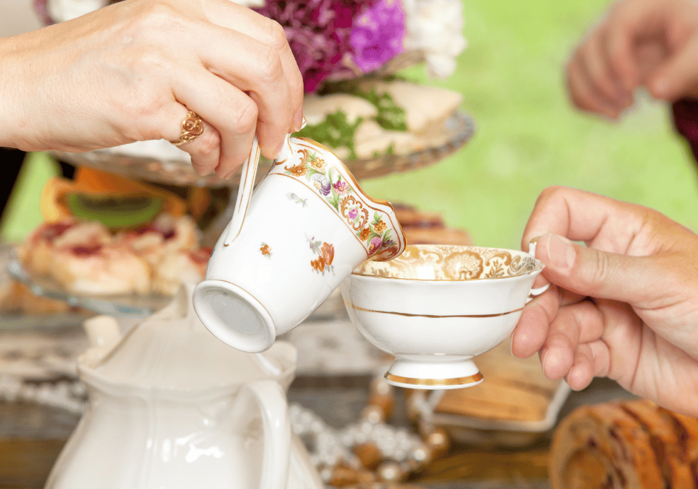 Pouring tea into teacup at tea party