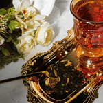 brewed and loose leaf orange chocolate black tea with gold teaspoon