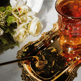 brewed and loose leaf orange chocolate black tea with gold teaspoon